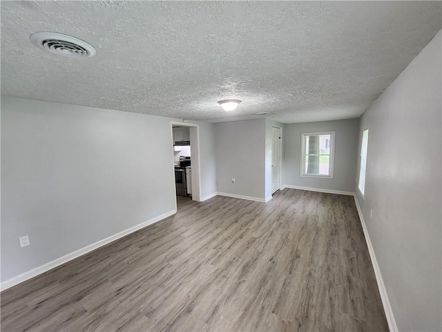 908 Davis St, Monroe, GA 30655 - unfurnished room with a textured ceiling, wood finished floors, visible vents, and baseboards