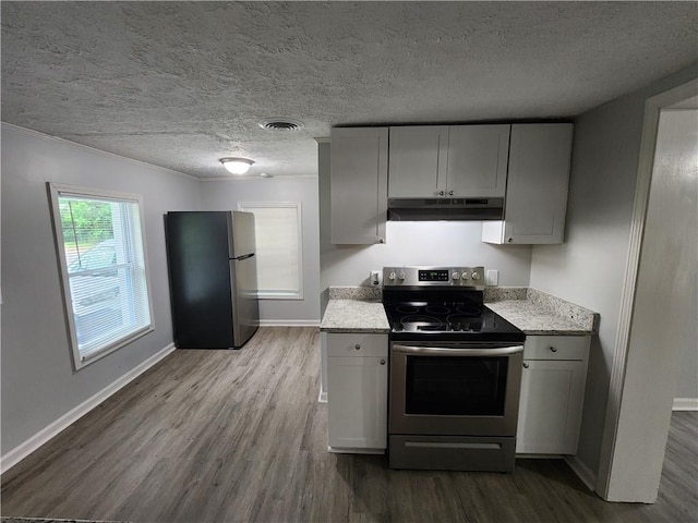 908 Davis St, Monroe, GA 30655 - kitchen with under cabinet range hood, visible vents, stainless steel appliances, and dark wood finished floors