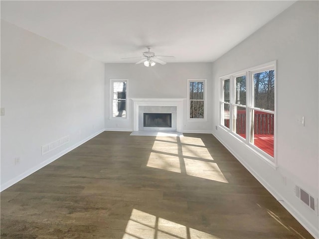 unfurnished living room featuring dark wood-style flooring, a fireplace with flush hearth, visible vents, and baseboards