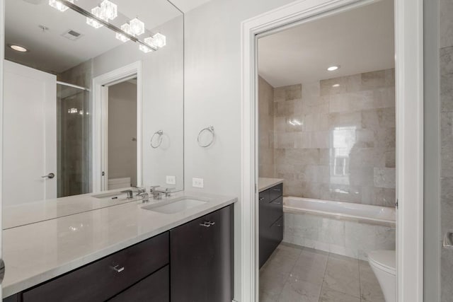 bathroom with tiled tub, toilet, a tile shower, and vanity