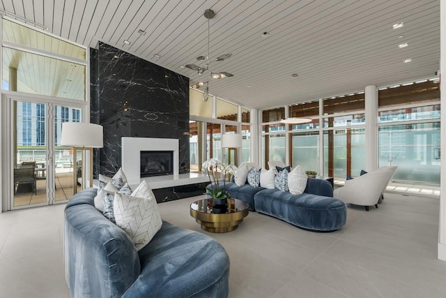 living area featuring floor to ceiling windows, wood ceiling, and a high end fireplace