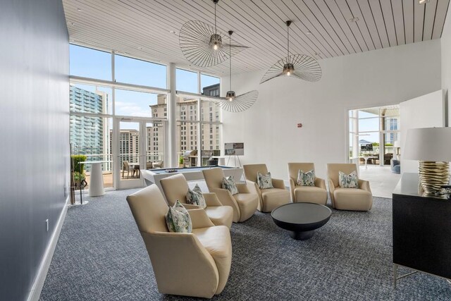 living room featuring wooden ceiling, floor to ceiling windows, carpet flooring, and a towering ceiling