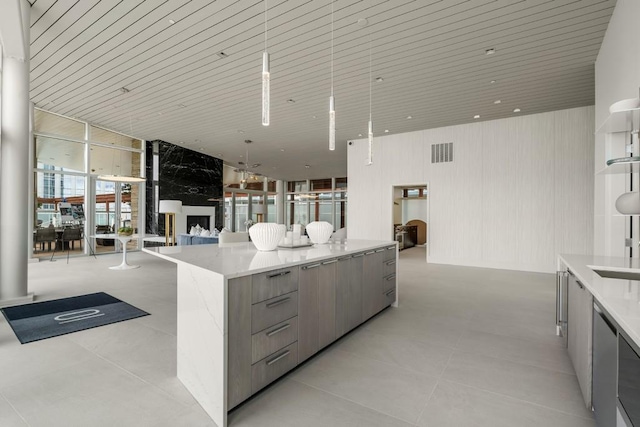 kitchen featuring a kitchen island, light stone countertops, a wall of windows, light tile patterned flooring, and wooden ceiling