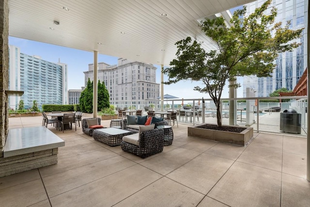 view of patio / terrace with central air condition unit, outdoor dining space, and a city view