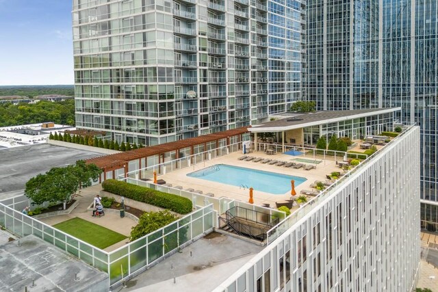 community pool with a patio and fence