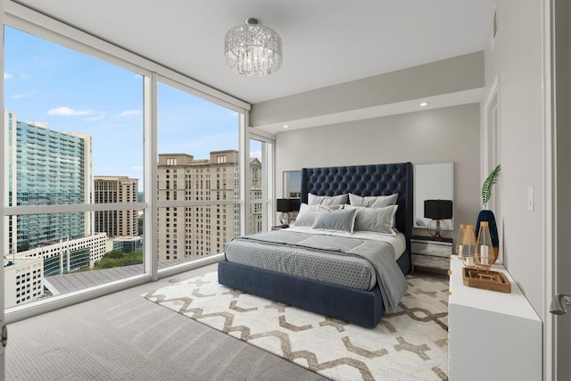 carpeted bedroom with expansive windows, a chandelier, and a view of city