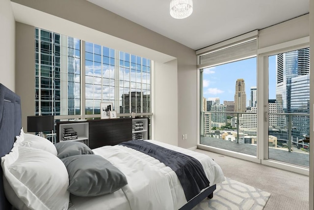 carpeted bedroom featuring floor to ceiling windows, access to outside, and a city view