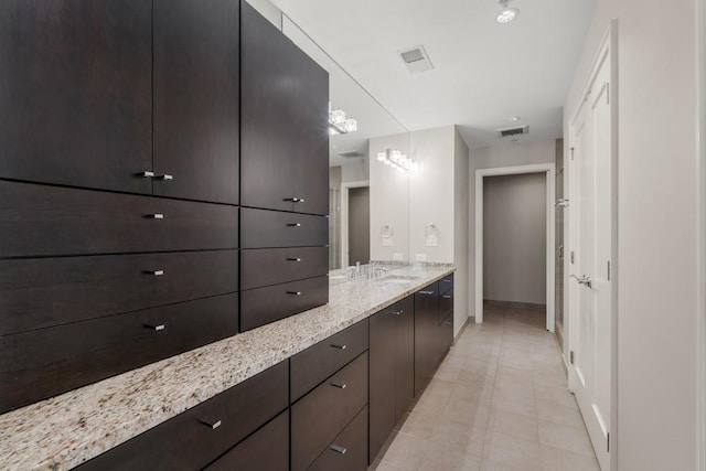 bathroom with tile patterned flooring, vanity, baseboards, and visible vents
