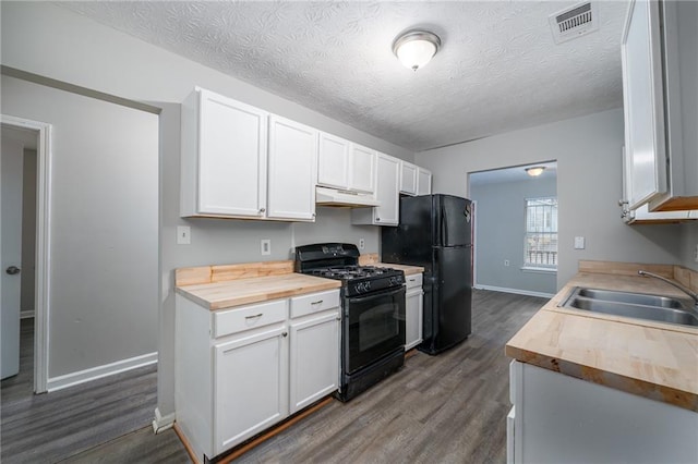 kitchen featuring white cabinetry, butcher block countertops, and black appliances