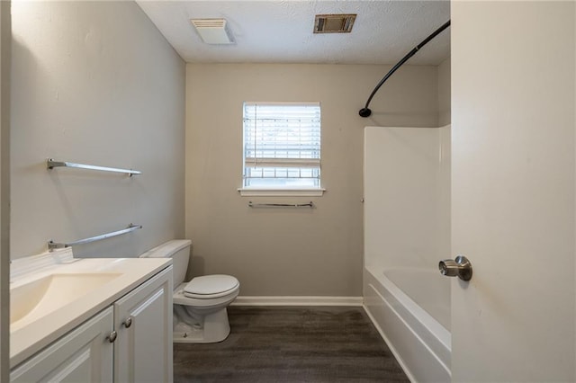 full bathroom featuring shower / bathtub combination, hardwood / wood-style flooring, vanity, toilet, and a textured ceiling