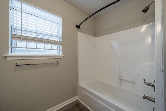 bathroom with shower / bath combination and a textured ceiling