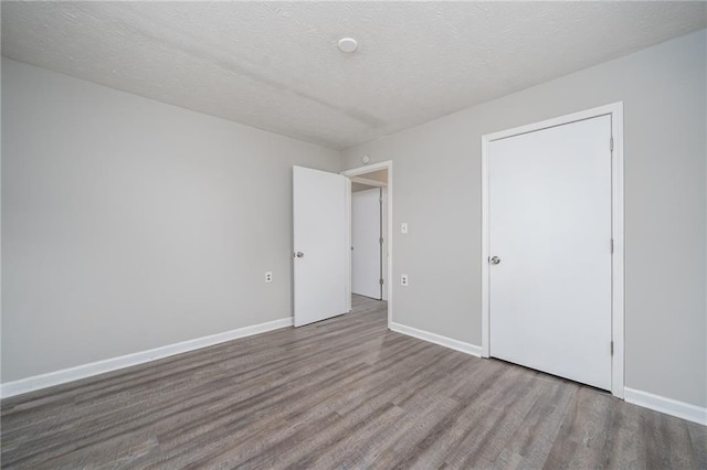 unfurnished bedroom with hardwood / wood-style flooring and a textured ceiling