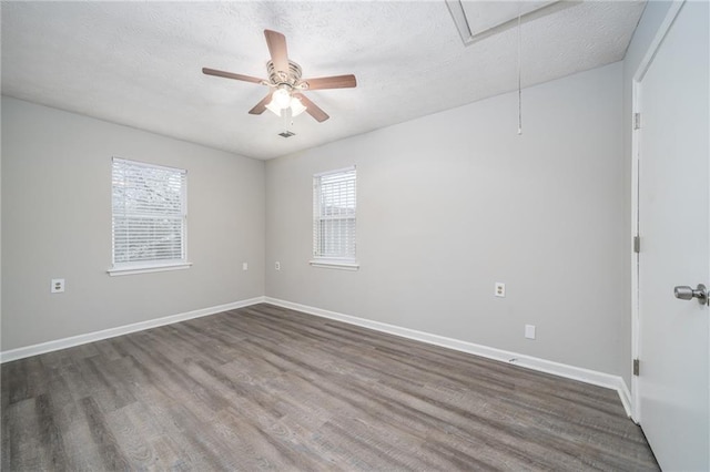 spare room featuring dark hardwood / wood-style flooring, a textured ceiling, and ceiling fan