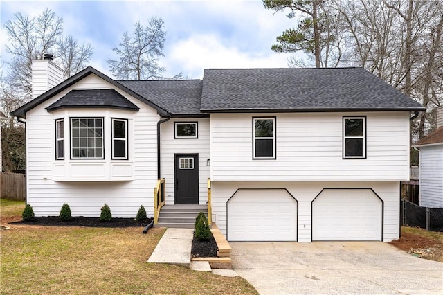 raised ranch with a garage and a front yard