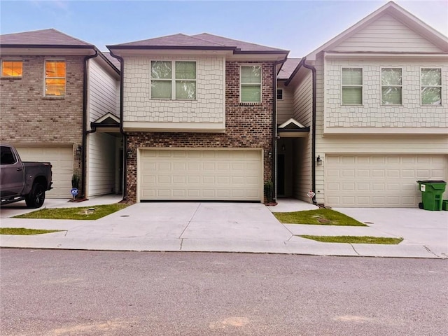 181 Dewy Rd Unit 70, Lilburn, GA 30047 - view of property featuring a garage, concrete driveway, and brick siding