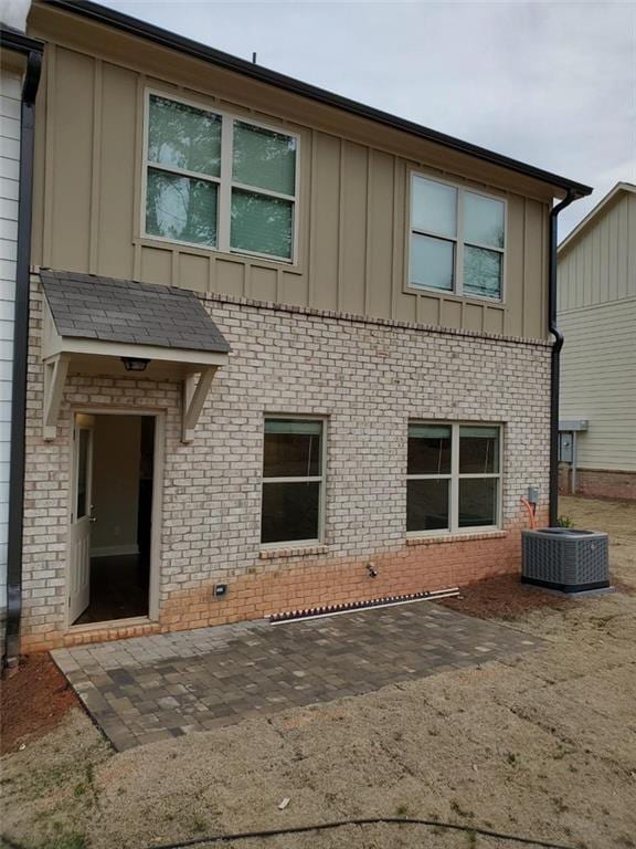 181 Dewy Rd Unit 70, Lilburn, GA 30047 - rear view of house with board and batten siding, brick siding, central AC, and a patio