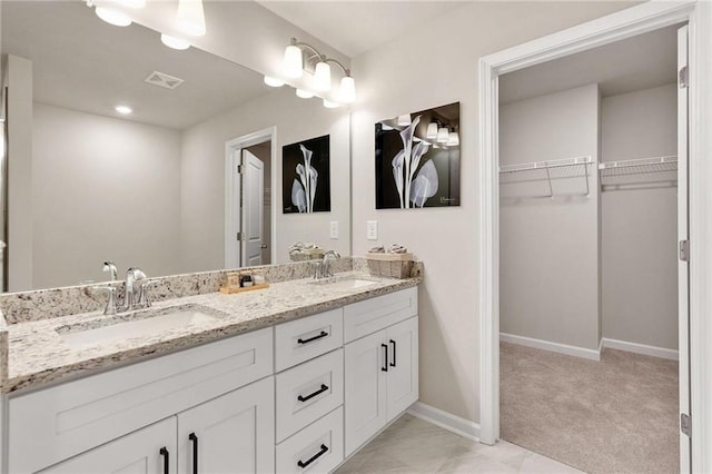 181 Dewy Rd Unit 70, Lilburn, GA 30047 - bathroom with a walk in closet, baseboards, and double vanity