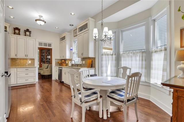 dining room featuring sink, a chandelier, and dark hardwood / wood-style floors