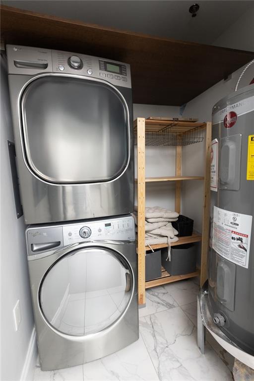 1280 W Peachtree St NW Unit 4003, Atlanta, GA 30309 - washroom featuring stacked washer / drying machine, electric water heater, and marble look tile flooring