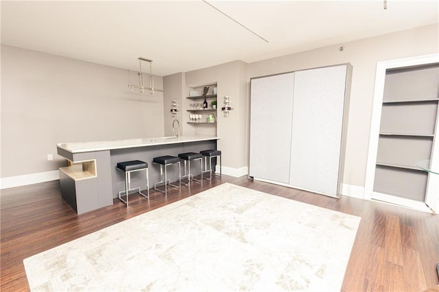 1280 W Peachtree St NW Unit 4003, Atlanta, GA 30309 - kitchen featuring open shelves, a kitchen breakfast bar, dark wood-style flooring, and a peninsula