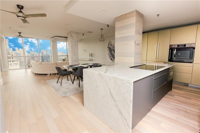 1280 W Peachtree St NW Unit 4003, Atlanta, GA 30309 - kitchen featuring black appliances, light wood-style floors, open floor plan, a view of skyline, and floor to ceiling windows