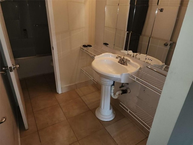 bathroom featuring tile patterned flooring, shower / tub combination, and sink