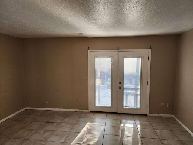 doorway featuring light tile patterned floors, a textured ceiling, and french doors