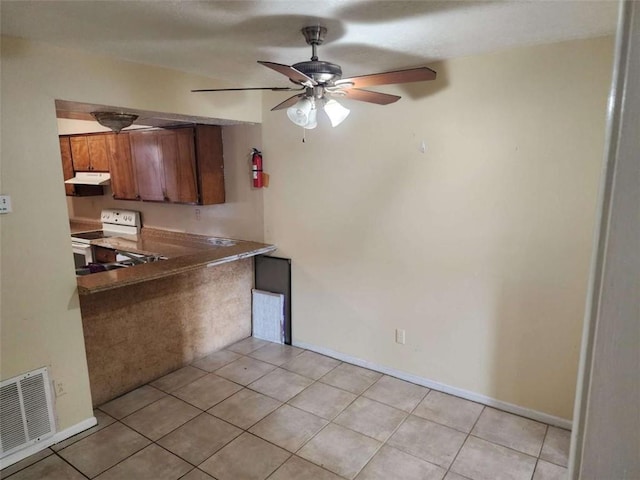 kitchen featuring light tile patterned floors, ceiling fan, and white electric range oven