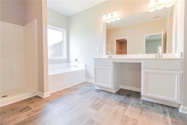 409 Glenn Trl, Winder, GA 30680 - bathroom featuring double vanity, a bath, and wood finished floors