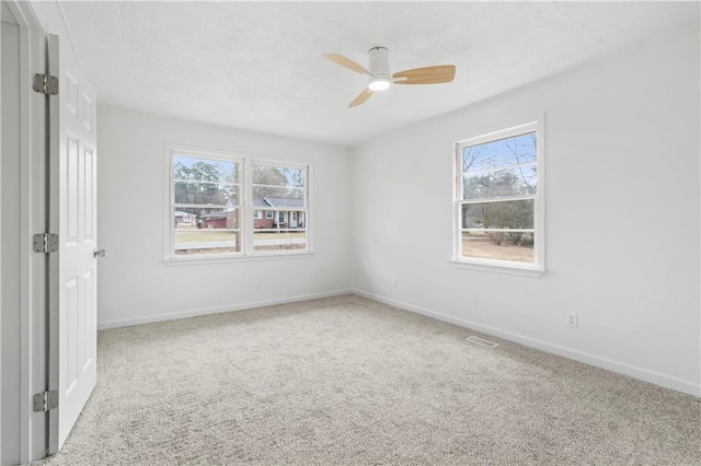 carpeted spare room with a textured ceiling and ceiling fan