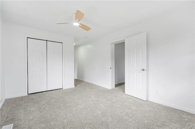 unfurnished bedroom featuring light colored carpet, a closet, and ceiling fan