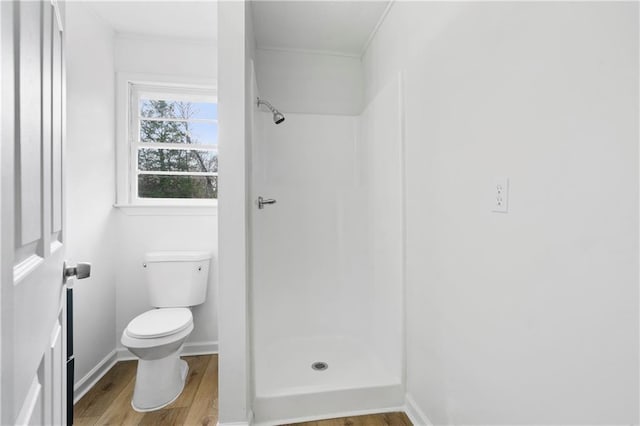 bathroom with wood-type flooring, toilet, and a shower