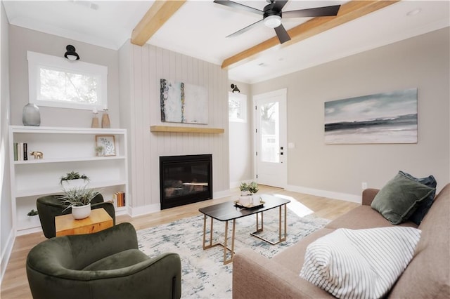 living room featuring a fireplace, ceiling fan, beamed ceiling, and light wood-type flooring