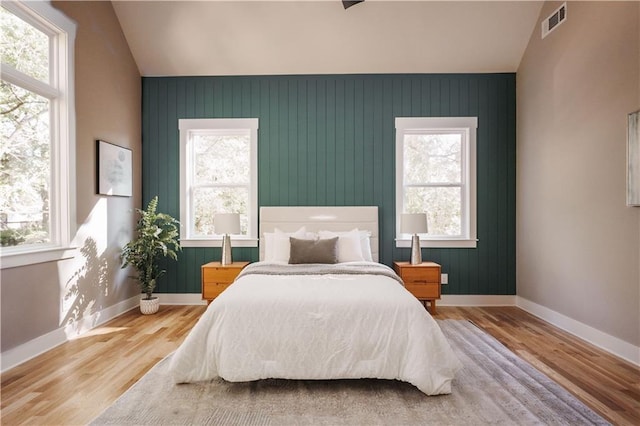 bedroom featuring multiple windows and lofted ceiling