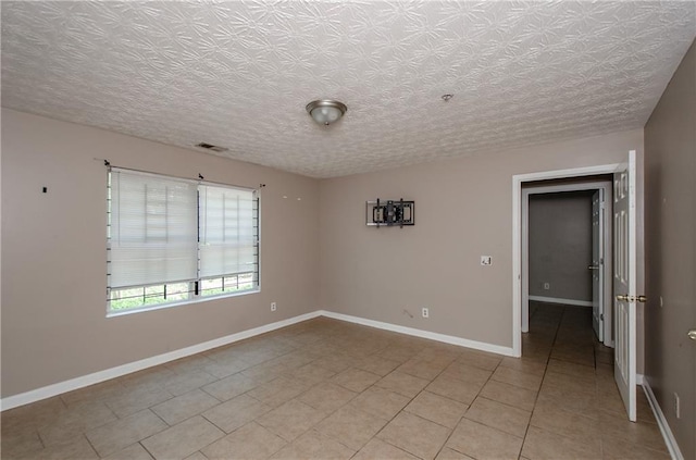 empty room featuring light tile patterned floors, baseboards, and visible vents