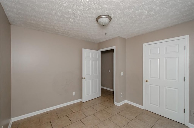 unfurnished bedroom featuring baseboards and light tile patterned flooring