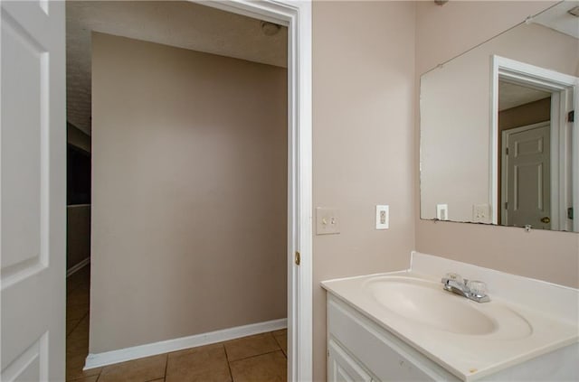 bathroom featuring baseboards, tile patterned flooring, and vanity