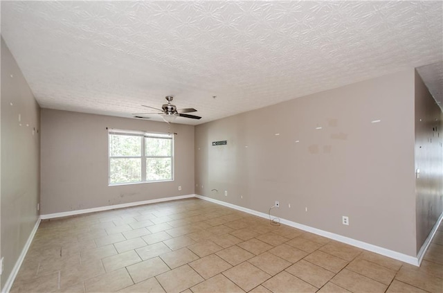 unfurnished room with a textured ceiling, light tile patterned floors, baseboards, and a ceiling fan