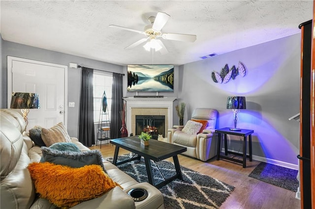 30 Creek Bottom Dr, Covington, GA 30014 - living room with a textured ceiling, a ceiling fan, wood finished floors, and a tile fireplace