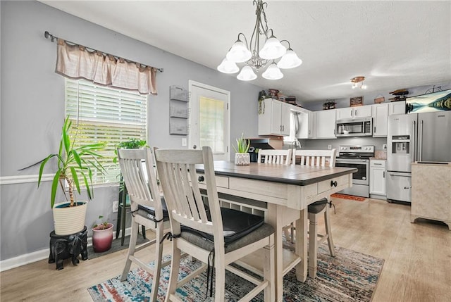 30 Creek Bottom Dr, Covington, GA 30014 - dining room with light wood-type flooring and a chandelier