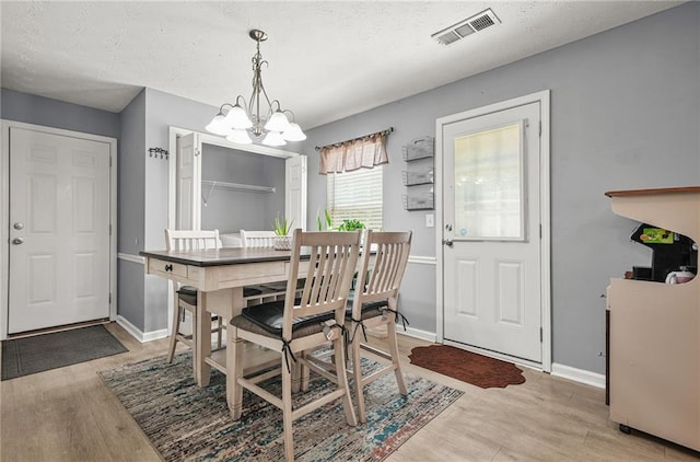 30 Creek Bottom Dr, Covington, GA 30014 - dining area with a chandelier, light wood-style flooring, and a textured ceiling