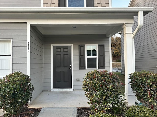 view of exterior entry with a porch