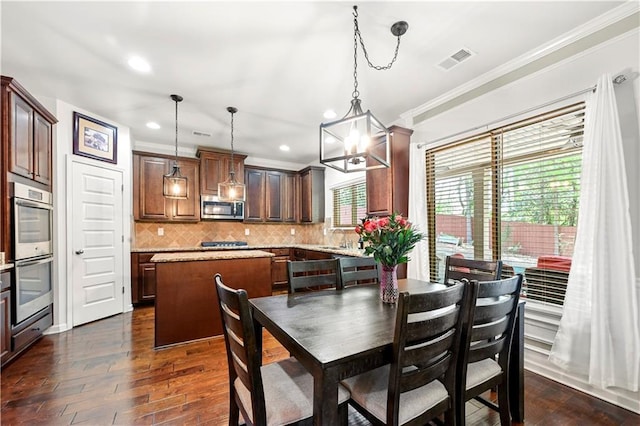 dining area featuring ornamental molding, a chandelier, recessed lighting, dark wood-type flooring, and visible vents