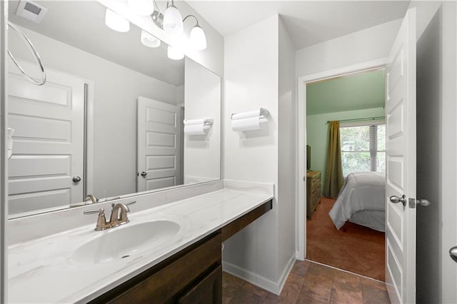 bathroom featuring stone finish flooring, vanity, visible vents, and baseboards