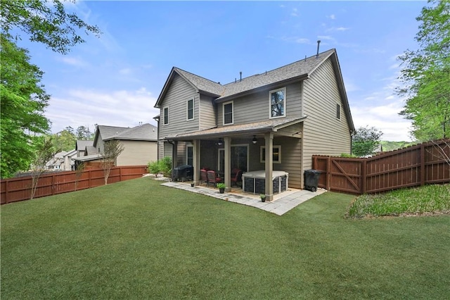 back of house featuring a shingled roof, a yard, a patio area, and a fenced backyard