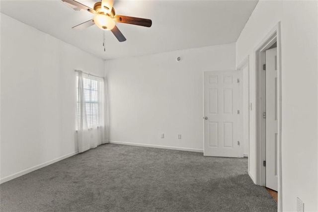 carpeted empty room featuring ceiling fan and baseboards