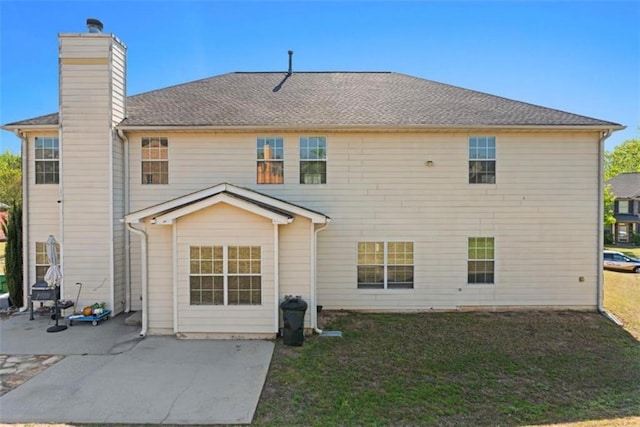 back of property with a patio area, a chimney, and a yard