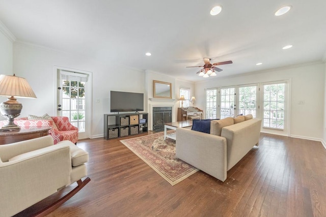 living room with ceiling fan, crown molding, dark wood-type flooring, and french doors