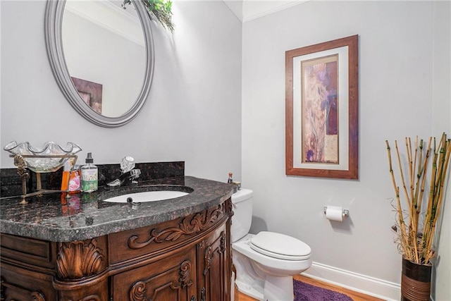 bathroom with vanity, toilet, and ornamental molding