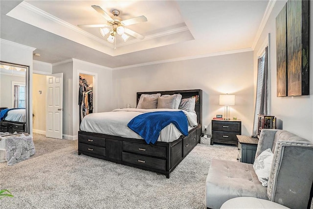 bedroom with light carpet, a raised ceiling, ceiling fan, a spacious closet, and a closet